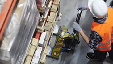 Personne qui récupère une palette grâce à un transpalette