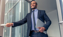 Homme qui ouvre une porte avec un ordinateur portable dans les mains