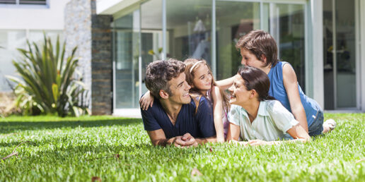 Famille qui est allongée dans l'herbe devant un bâtiment