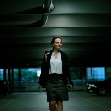 Femme avec un sac à dos et un dossier dans un parking