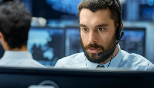 Homme avec un micro casque devant son PC