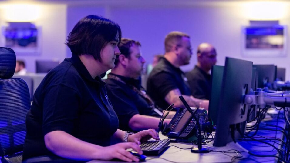 People sitting infront of computer screens in a alarm receiving centre
