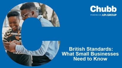 Two small business owners stand together smiling at a smartphone, framed by a large blue “C”, alongside Chubb branding and the headline “British Standards: What Small Businesses Need to Know”, promoting SME fire‑safety guidance and compliance support.